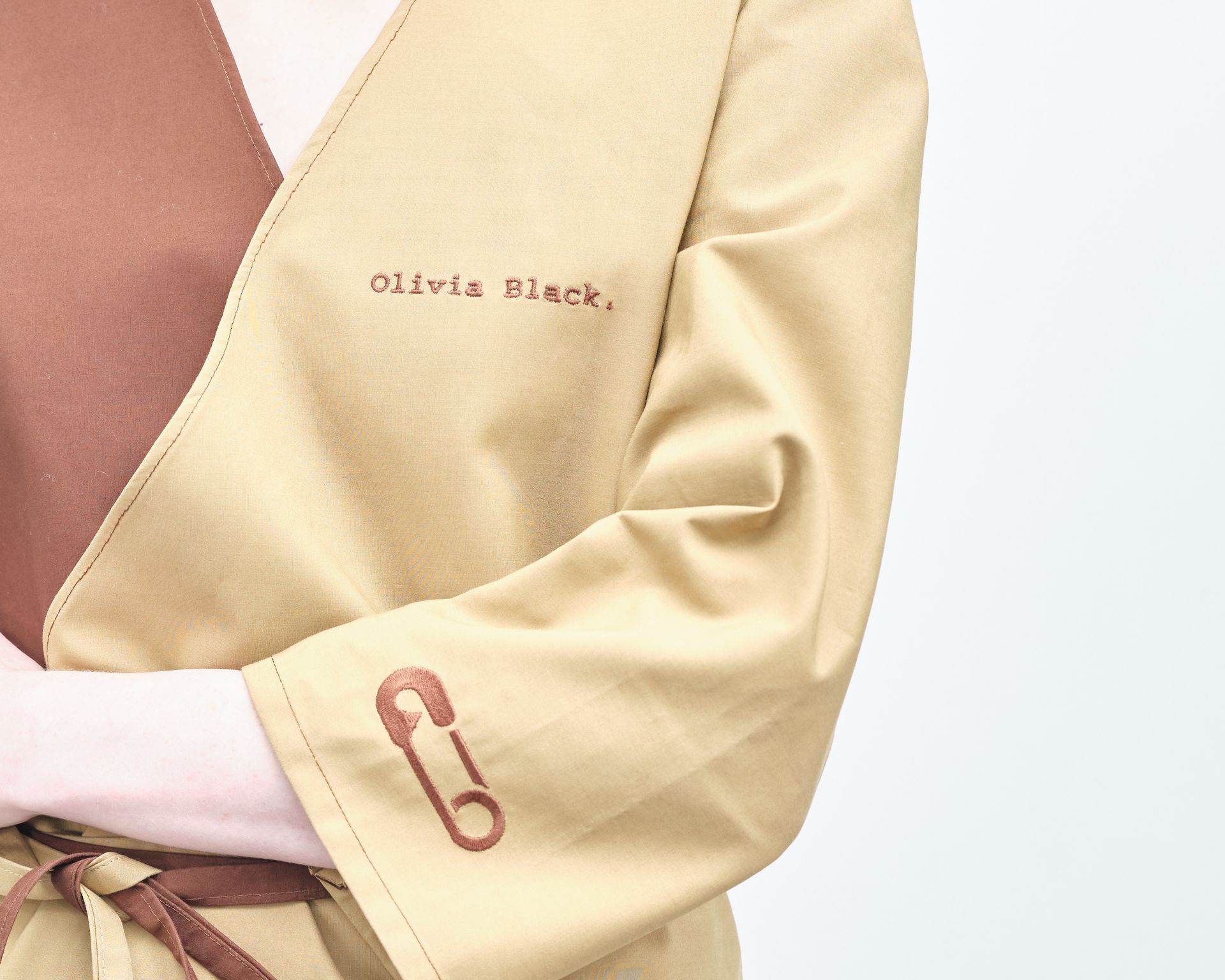 A close up of a person wearing a jacket that says olivia black