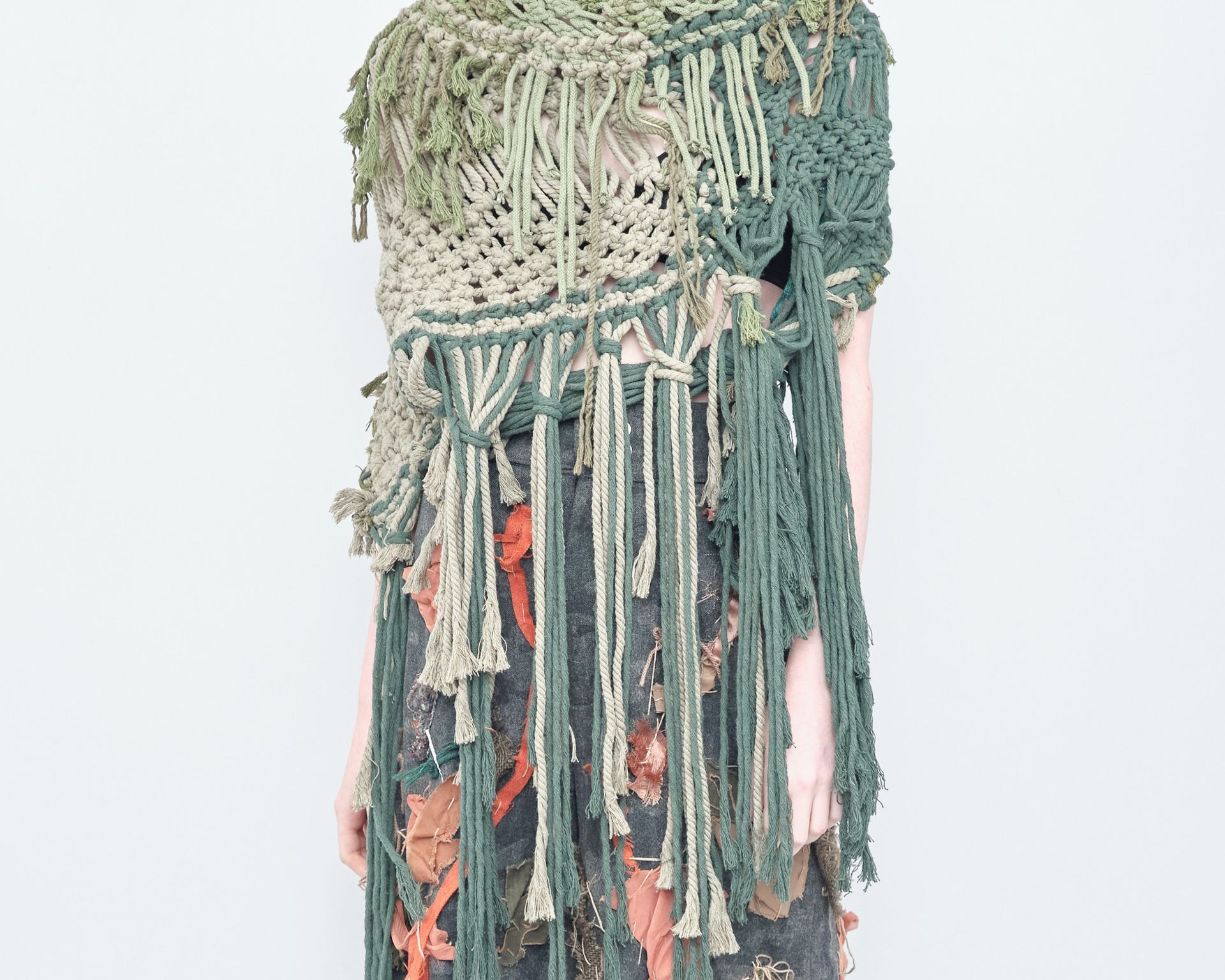 A woman is wearing a knitted scarf and a dress with fringe.