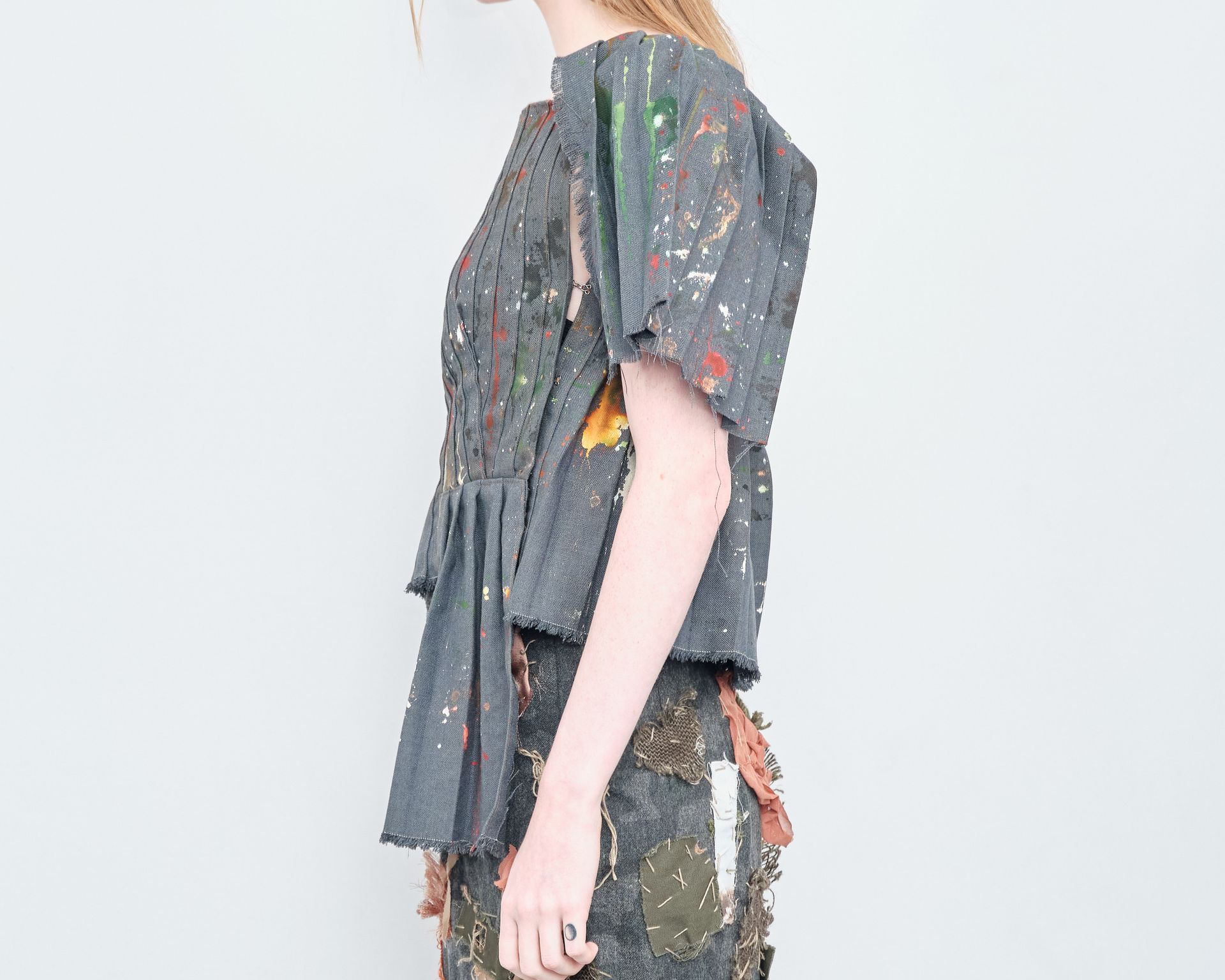 A woman is wearing a gray top and a black skirt.