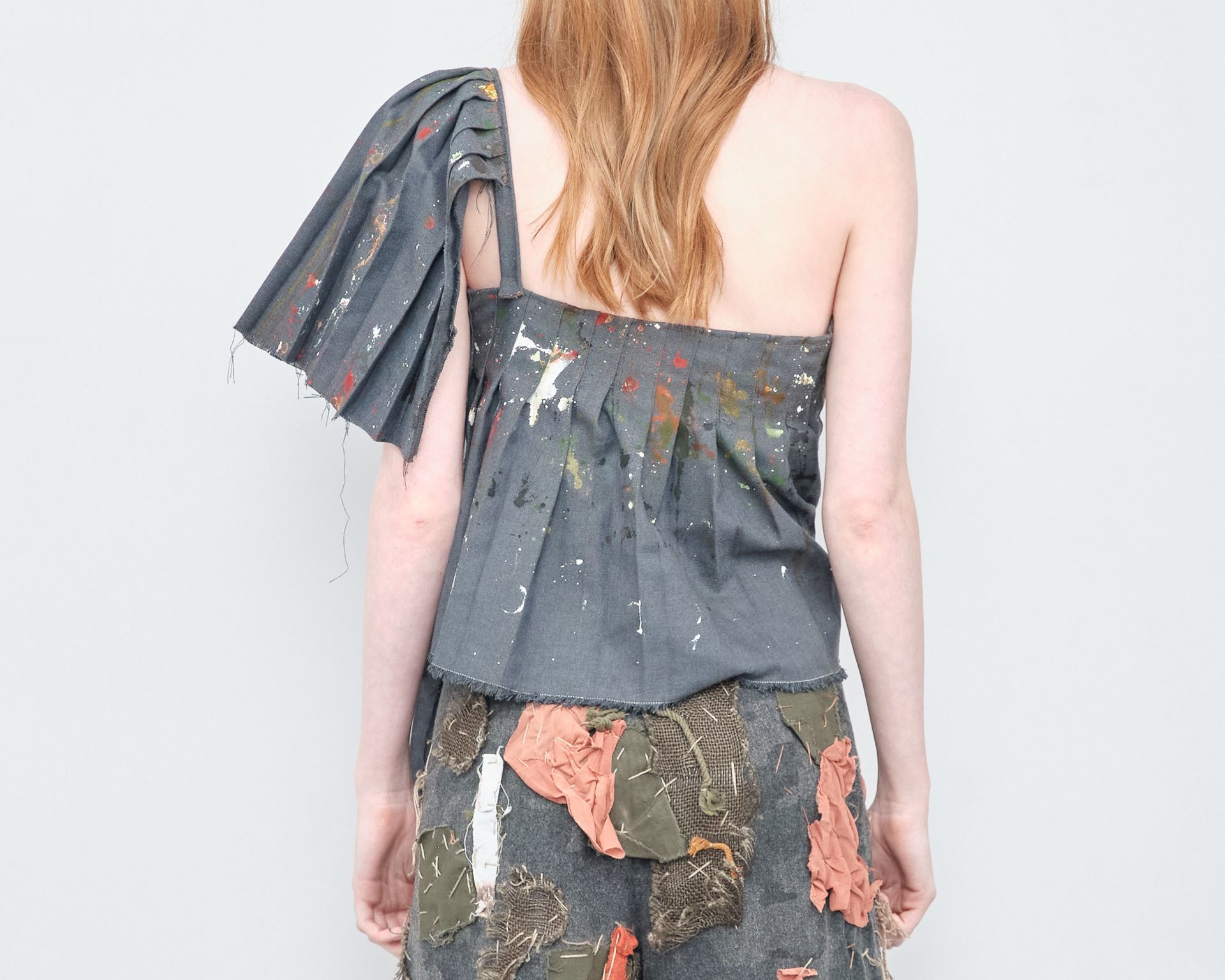 The back of a woman wearing a one shoulder top