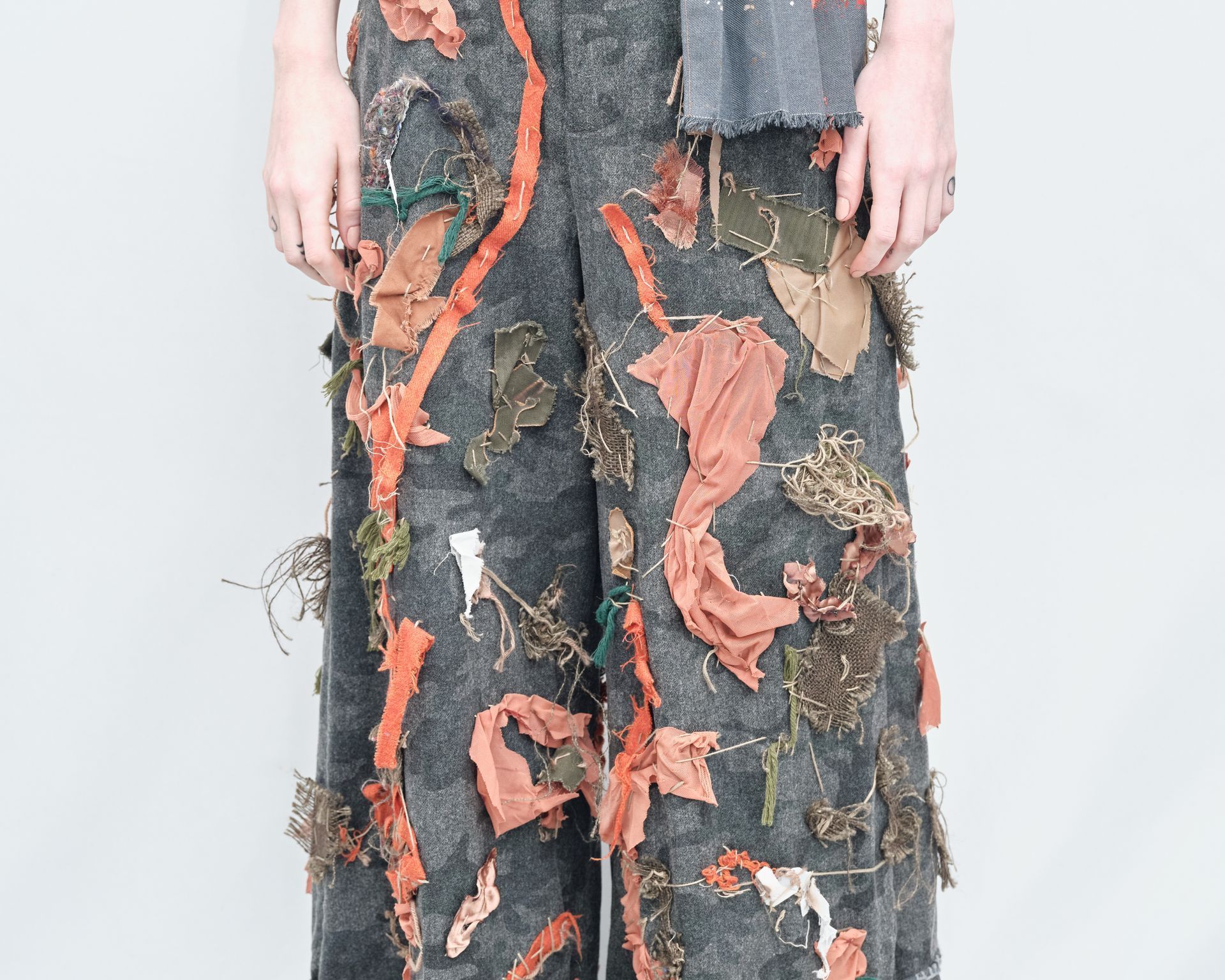 A person wearing a pair of pants with leaves on them
