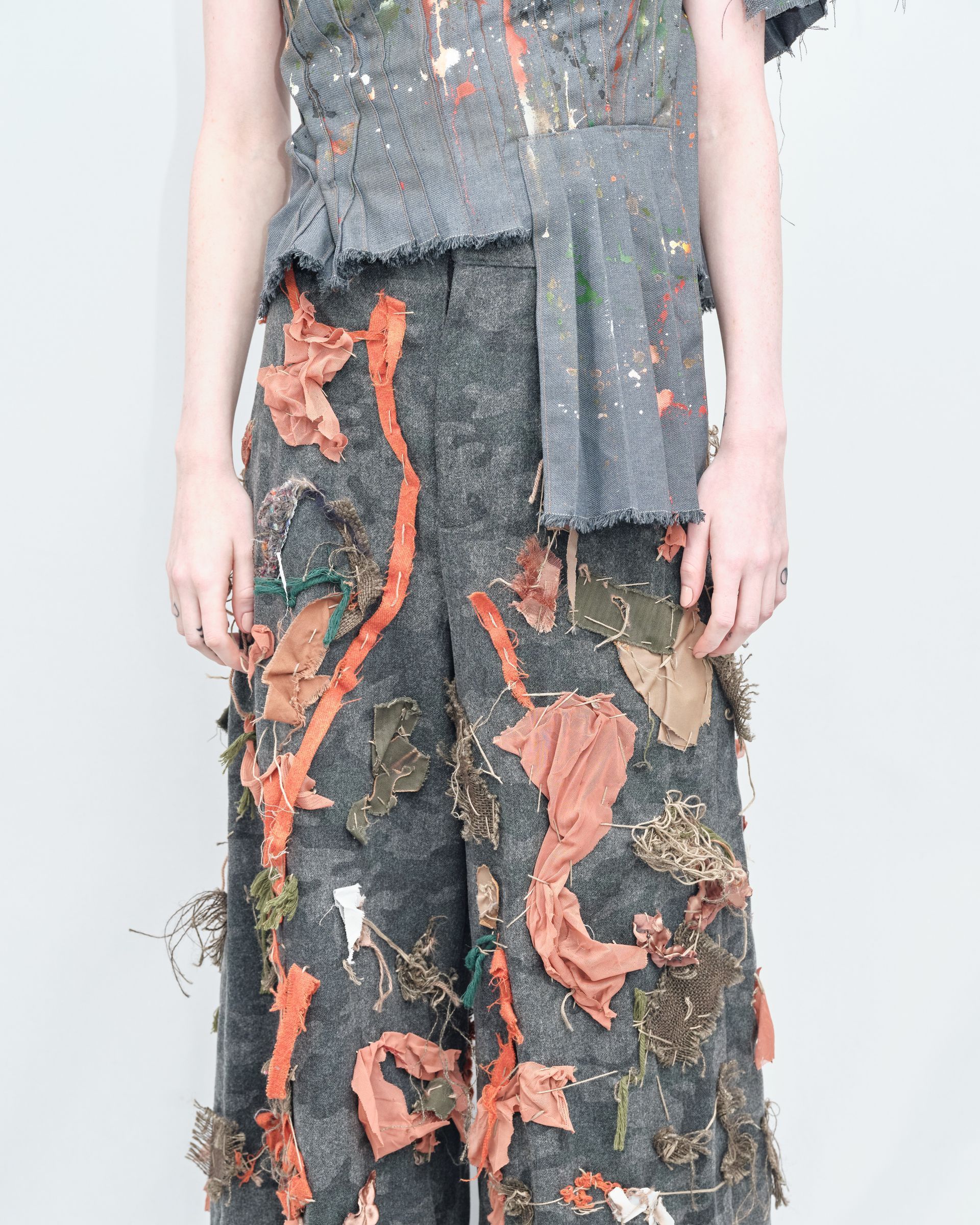 A person wearing a pair of pants with leaves on them