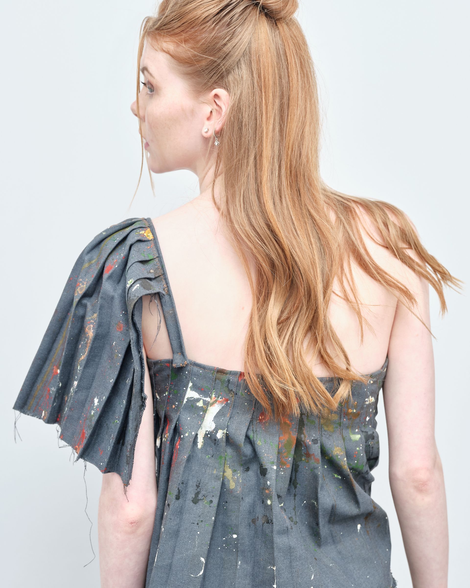 The back of a woman wearing a gray dress with ruffled sleeves