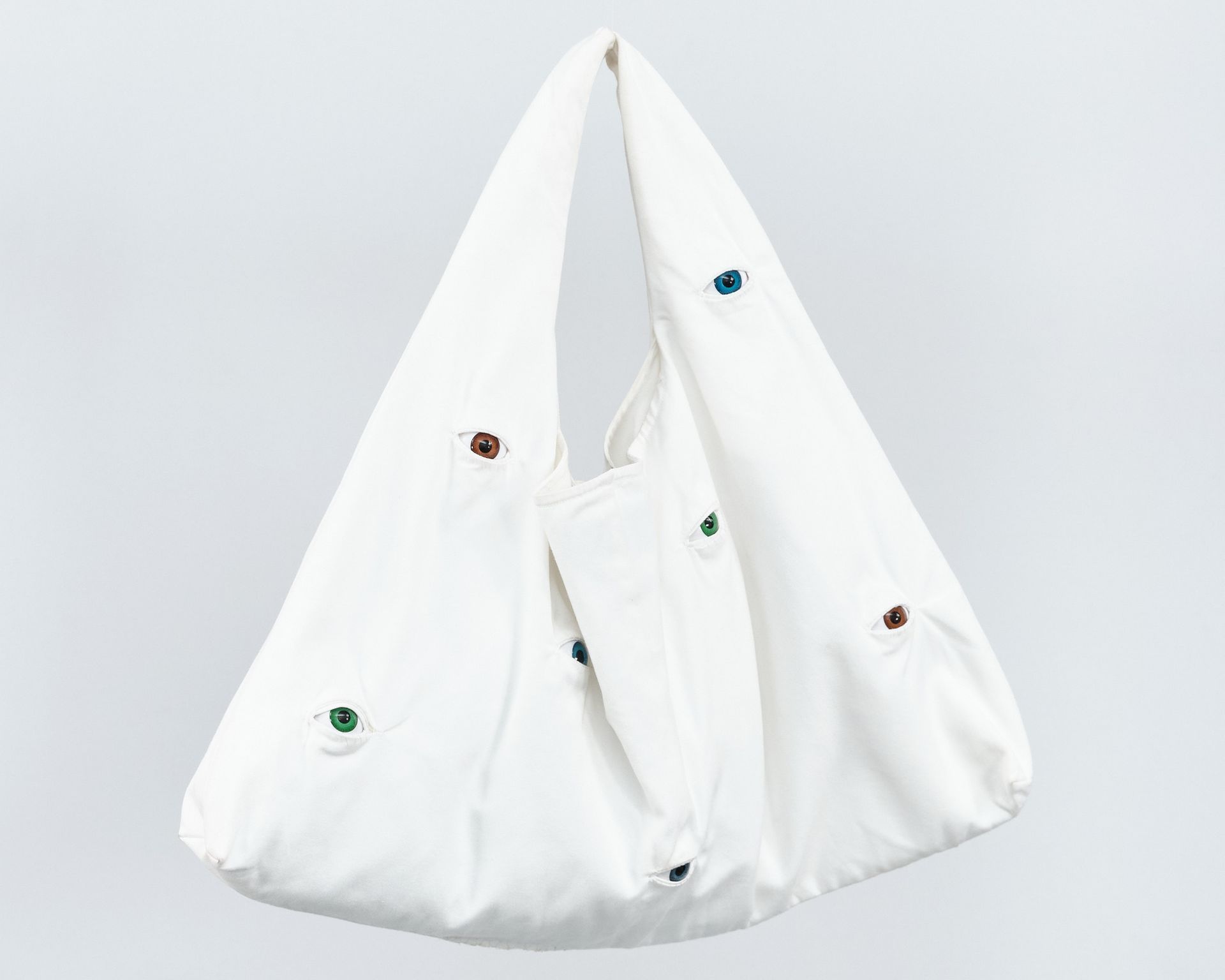 A white bag with the words `` all eyes on us '' embroidered on it.