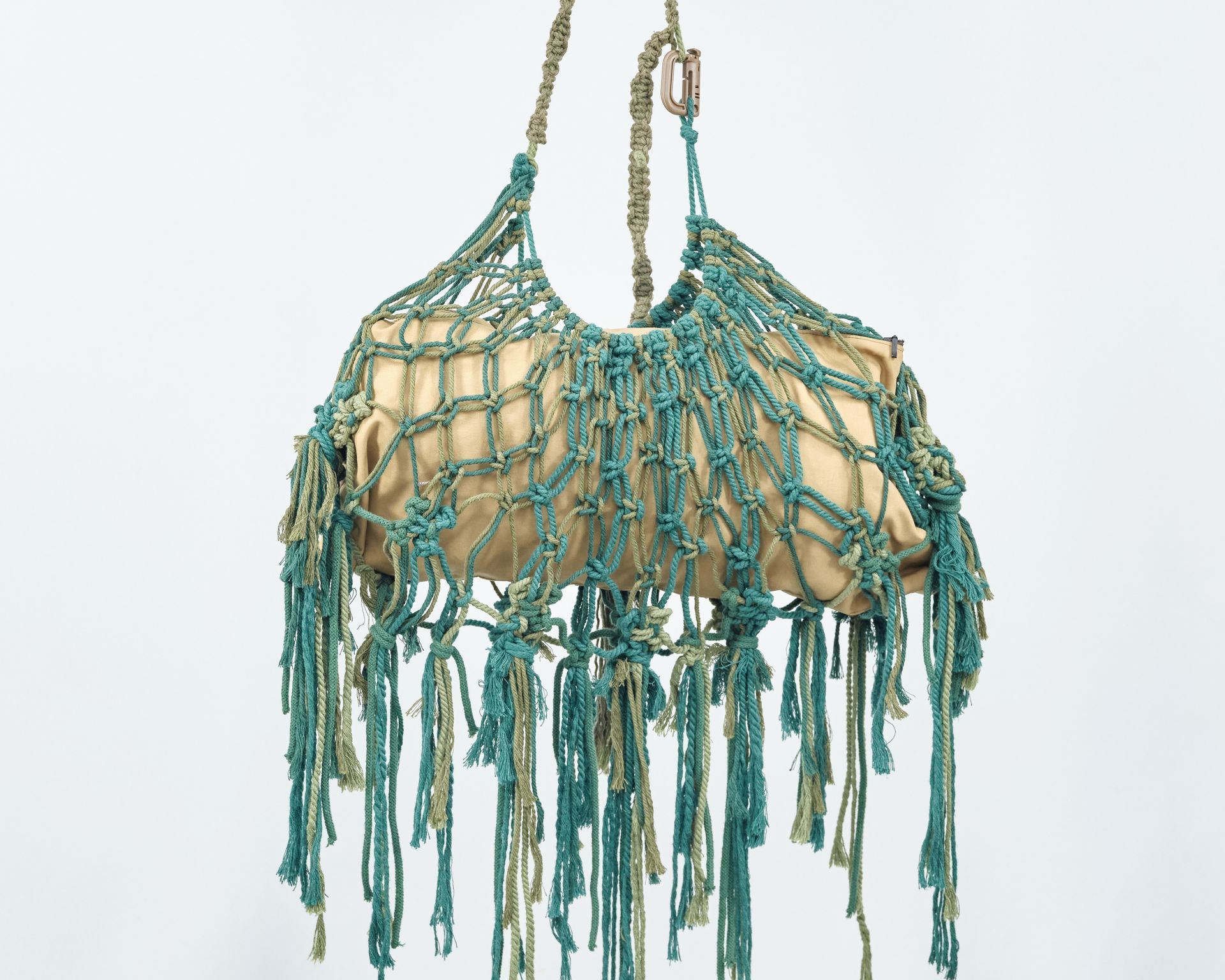 A purse with fringe is hanging from a string
