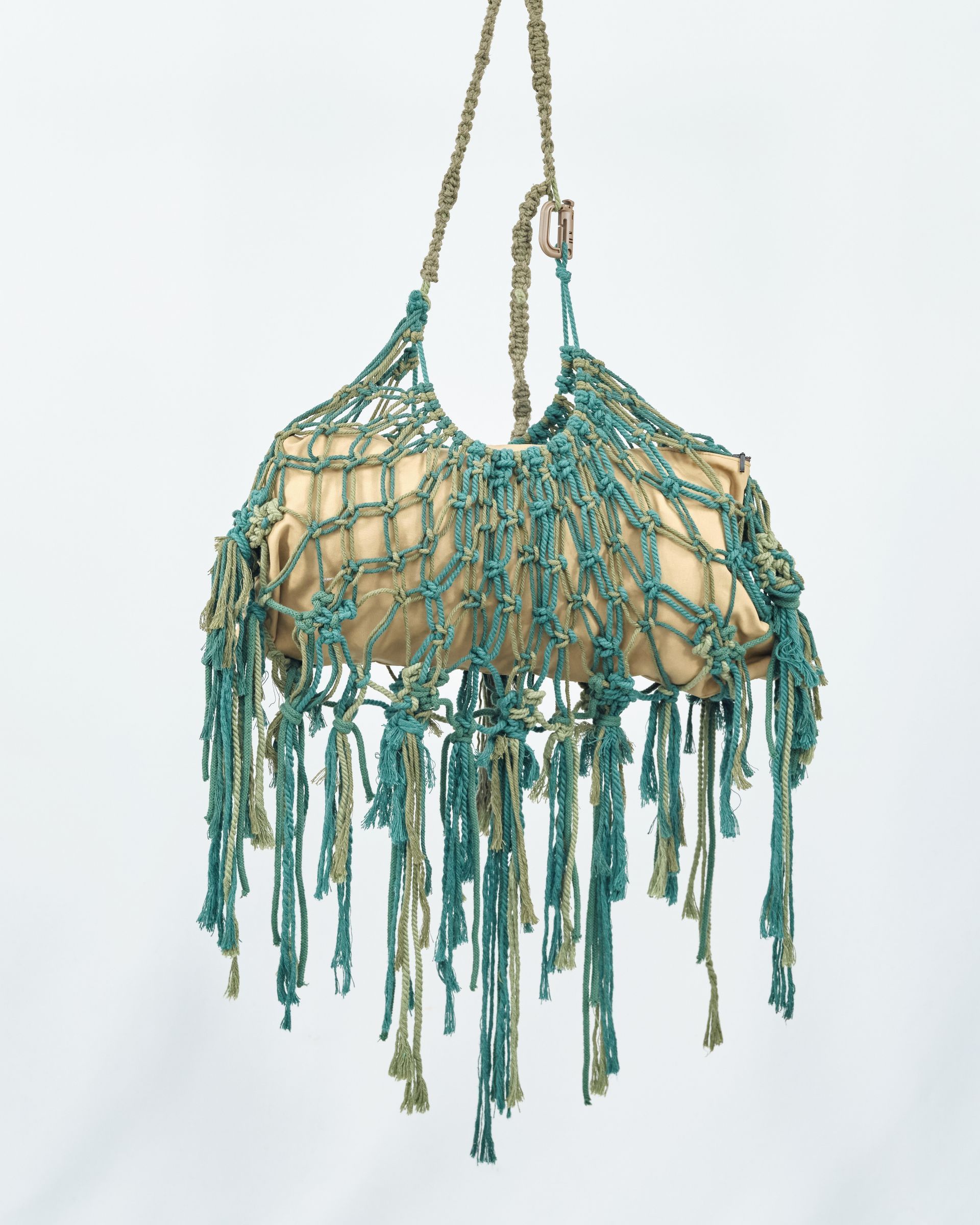 A purse with fringe is hanging from a string