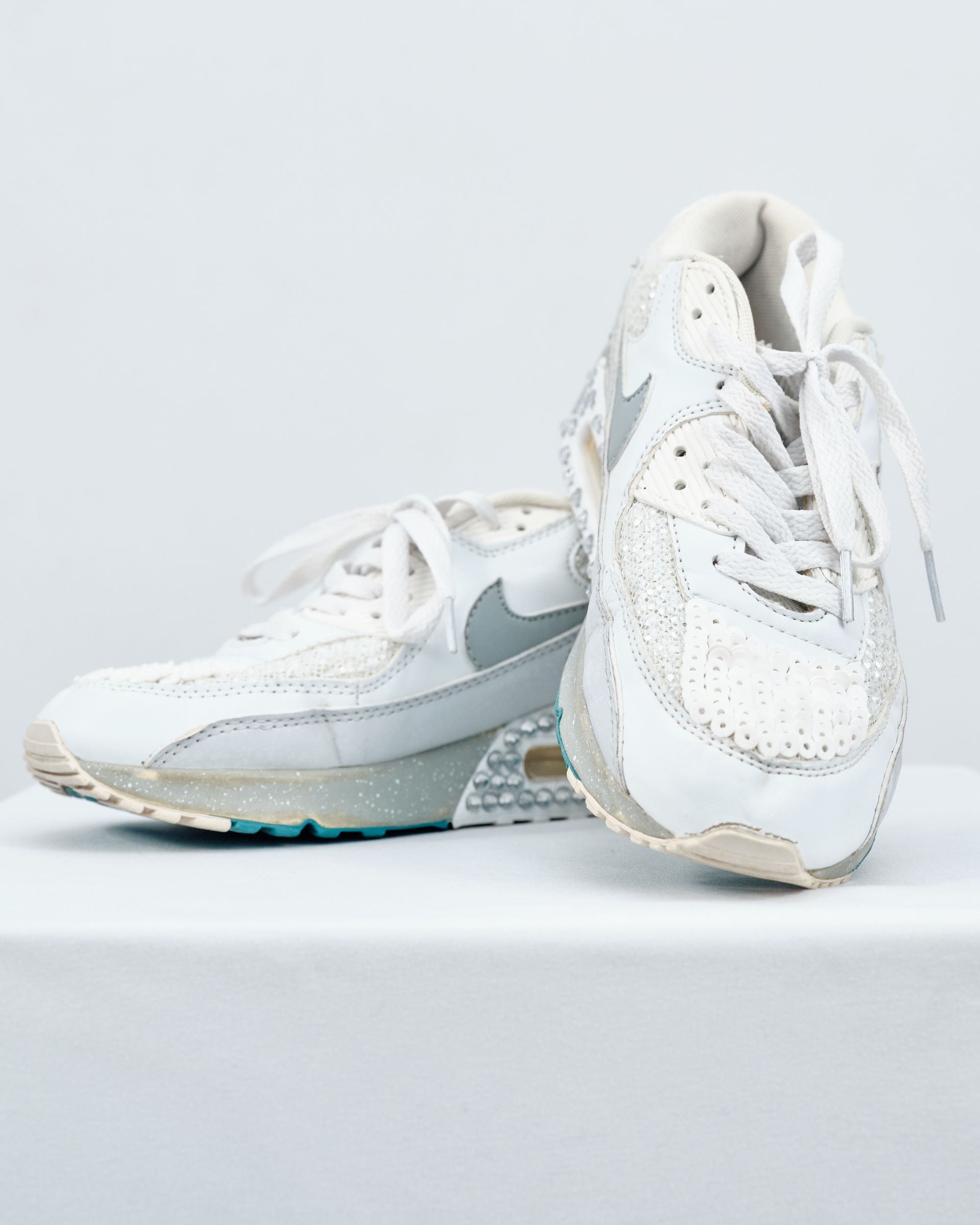 A pair of white nike air max sneakers are sitting on a white surface.