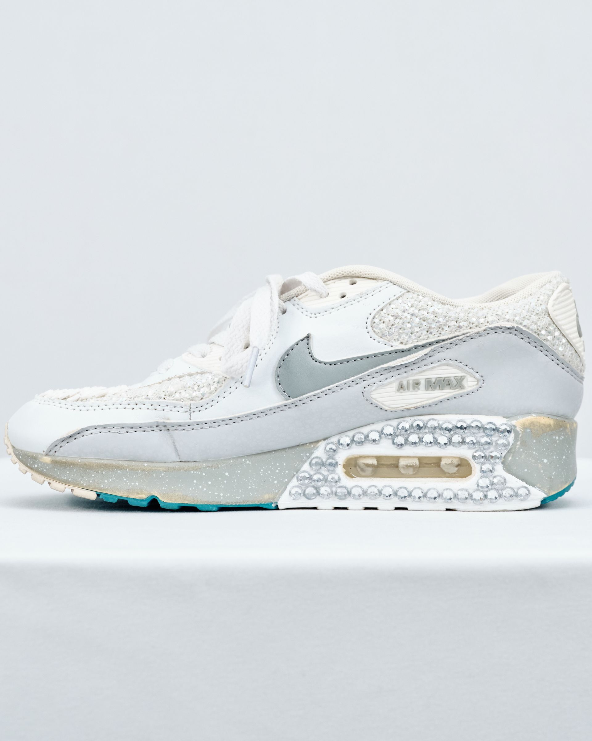 A pair of white nike air max sneakers are sitting on a white surface.