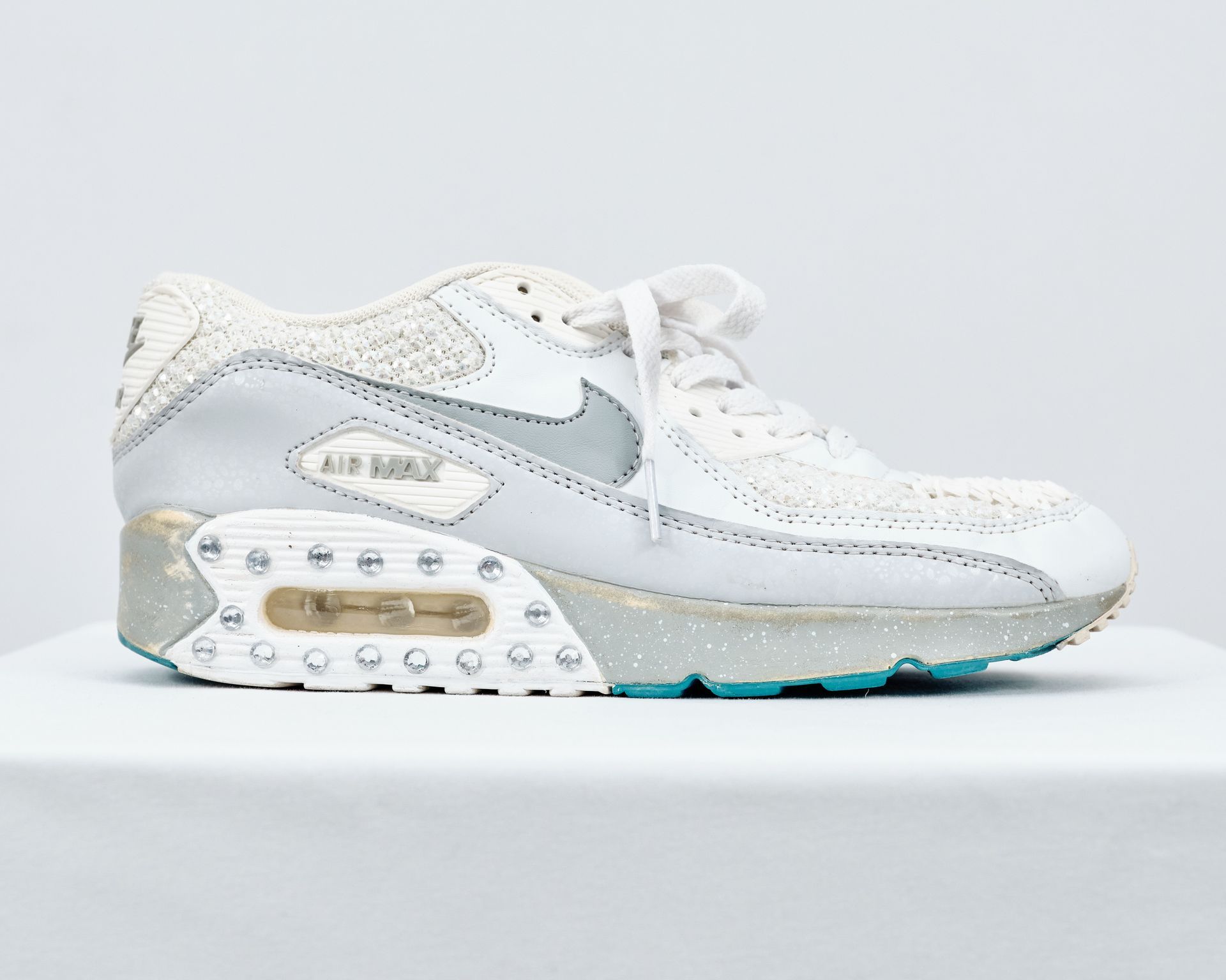 A pair of white nike air max sneakers are sitting on a white surface.