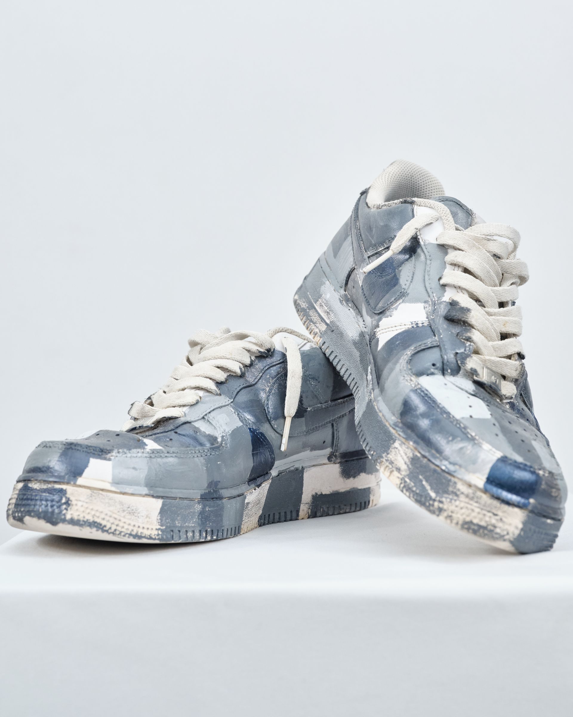 A pair of blue and white nike air force 1 sneakers are sitting on a white table.