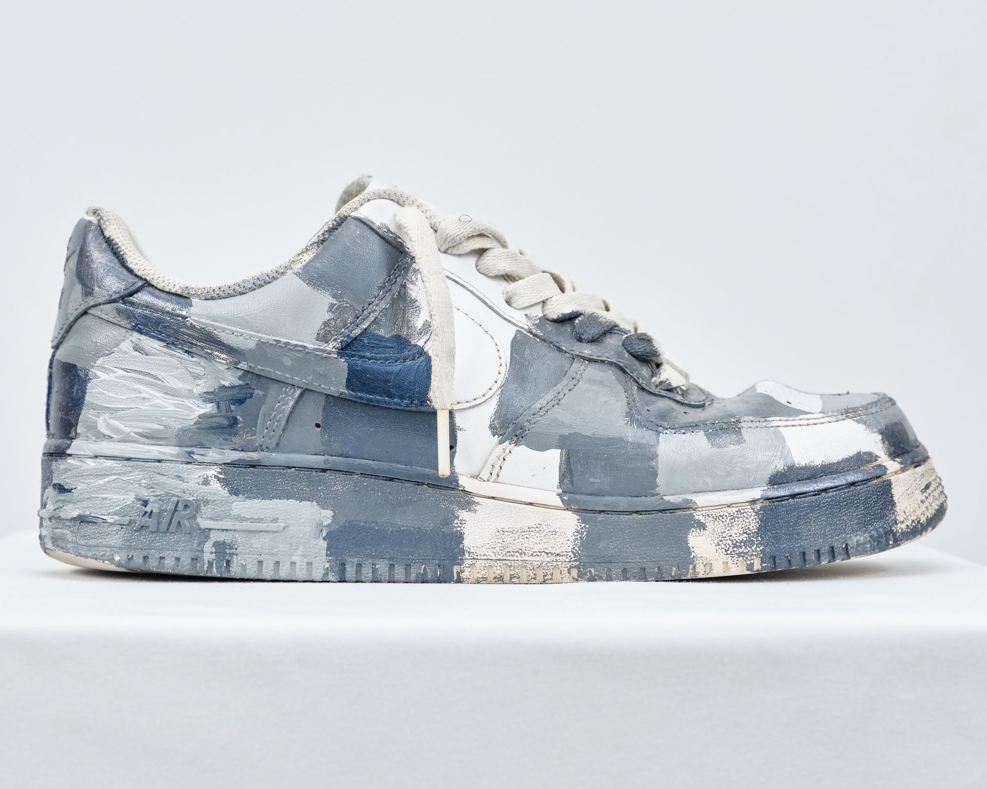 A pair of blue and white nike air force 1 sneakers are sitting on a white table.