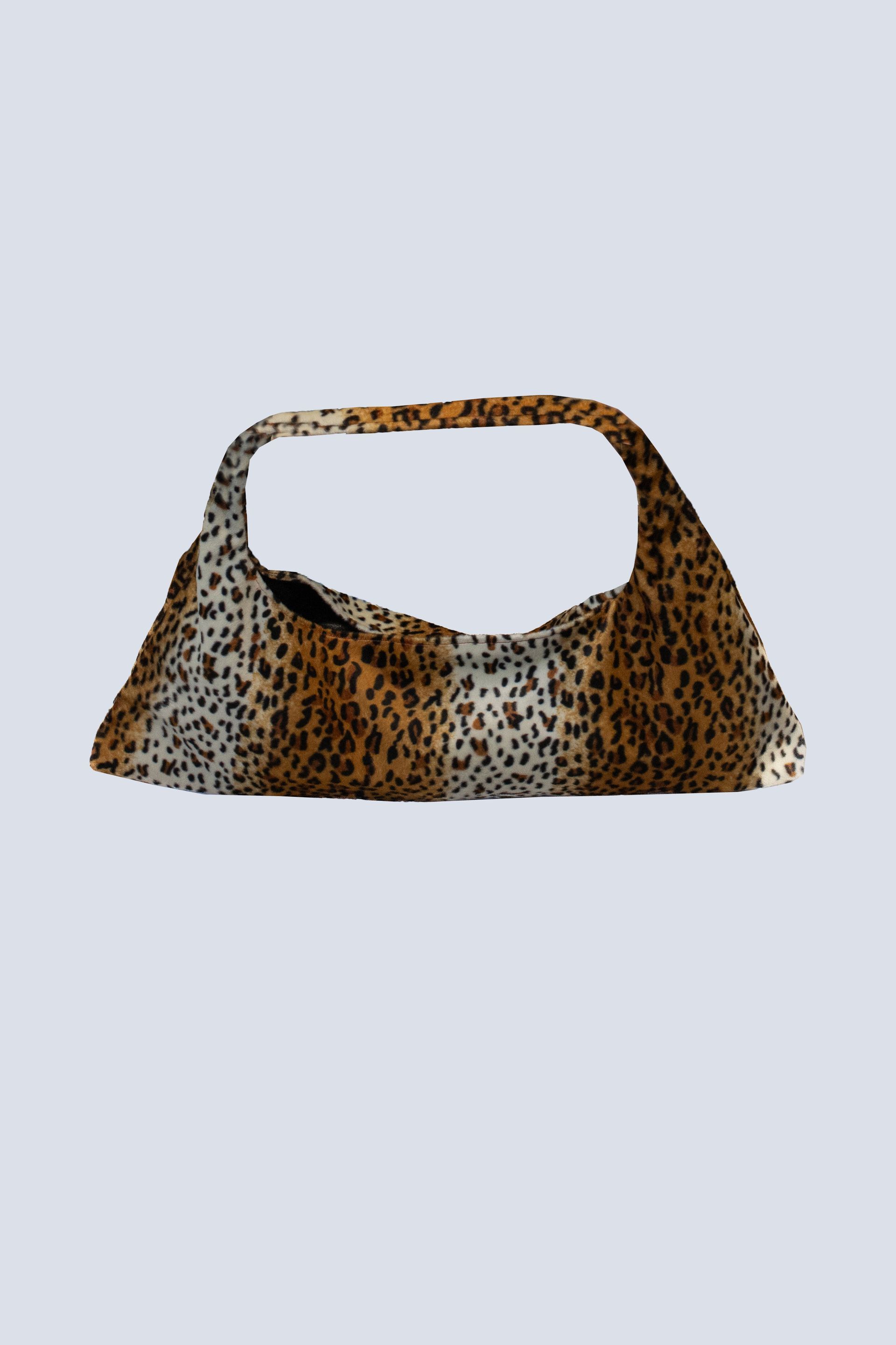 A leopard print purse with a handle on a white background.