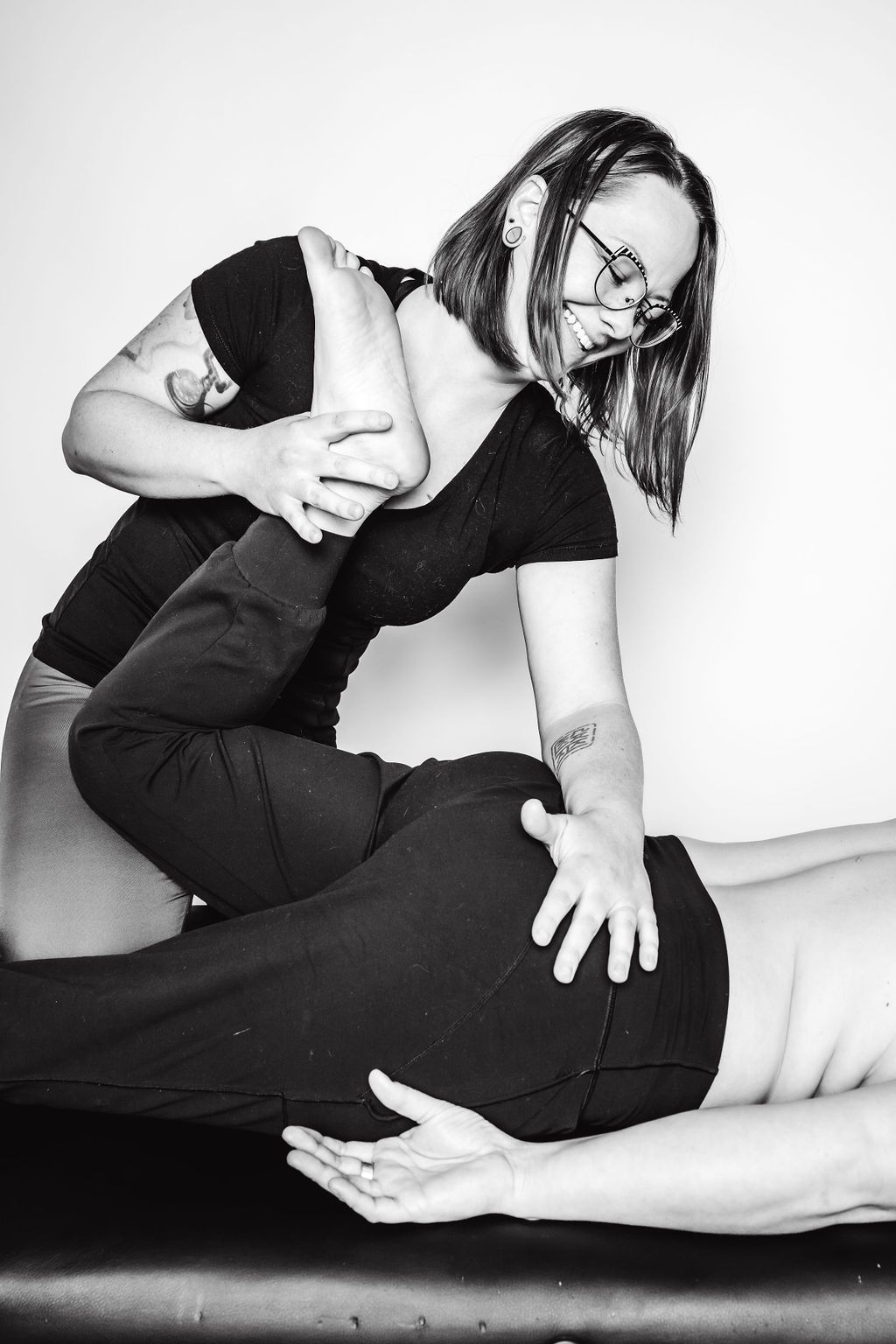 Black-and-white photo of two people in a grappling pose on a mat.