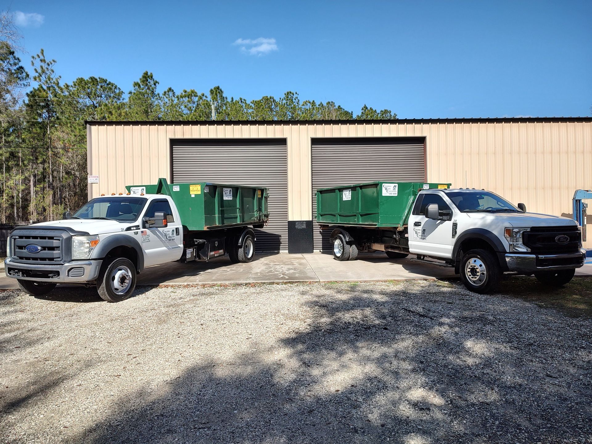 Two dump trucks are parked in front of a building.