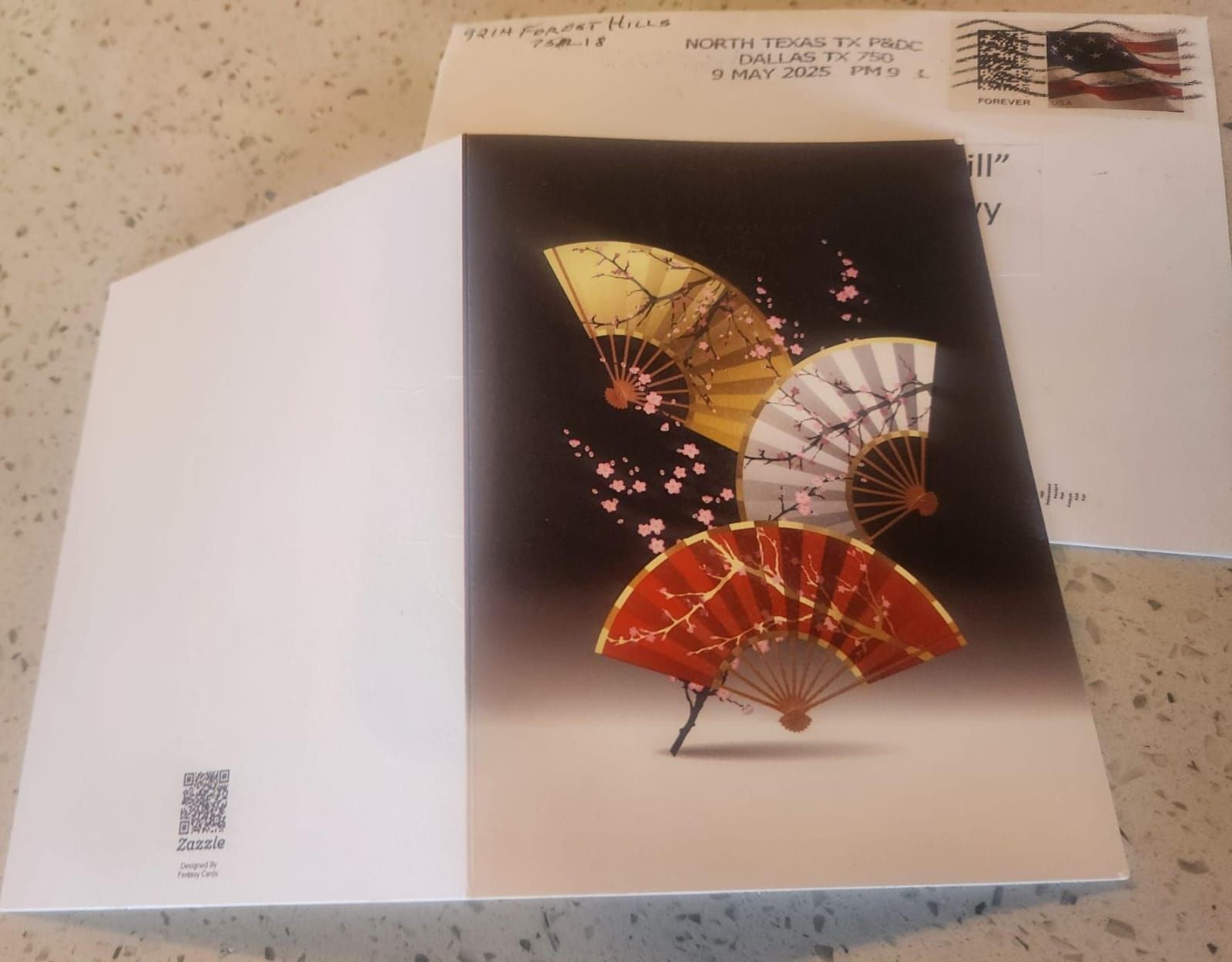 Greeting card with gold, white, and red fans and an envelope with a stamp.