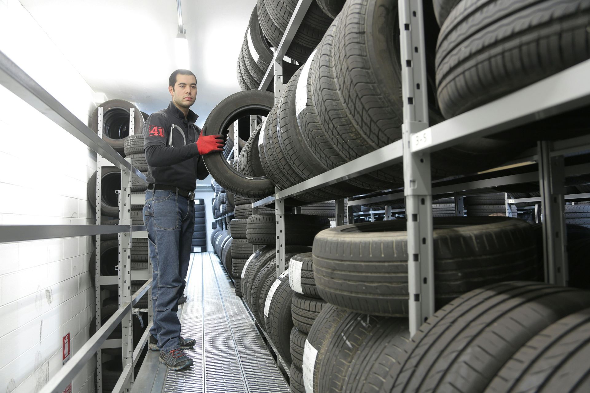 man grabbing tire from shelf