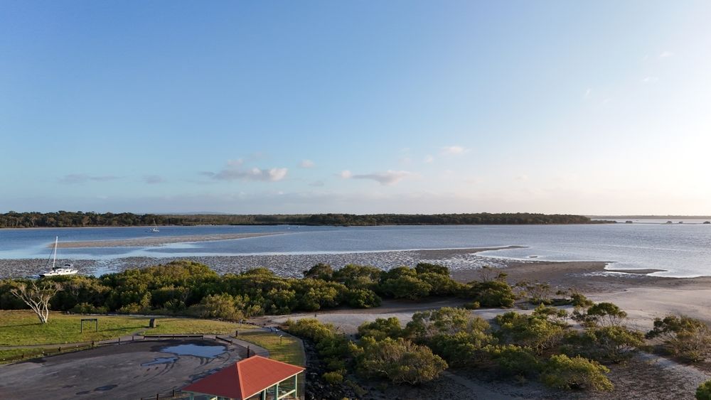 An Aerial View of a Large Body of Water With a House in the Foreground — Alert Smoke Alarm Compliance in Tin Can Bay, QLD