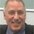 A man in a suit and tie is smiling for the camera.