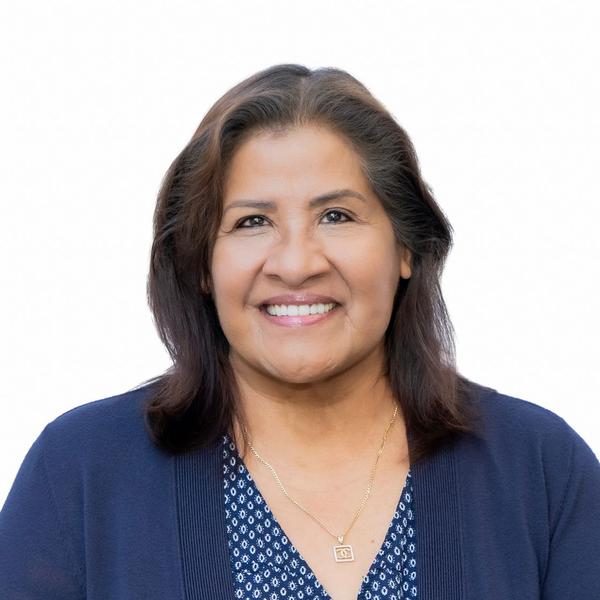 A man in a suit and tie is standing in front of a white background.