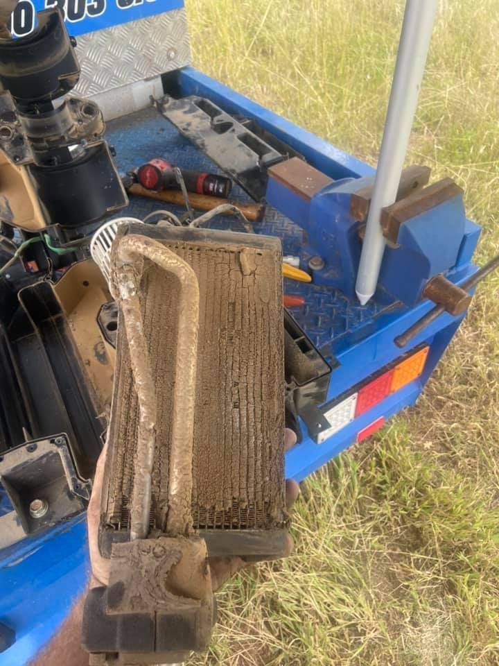 Dirty Vehicle Radiator Mounted on a Blue truck — Auto Air Conditioning Repairs Tamworth