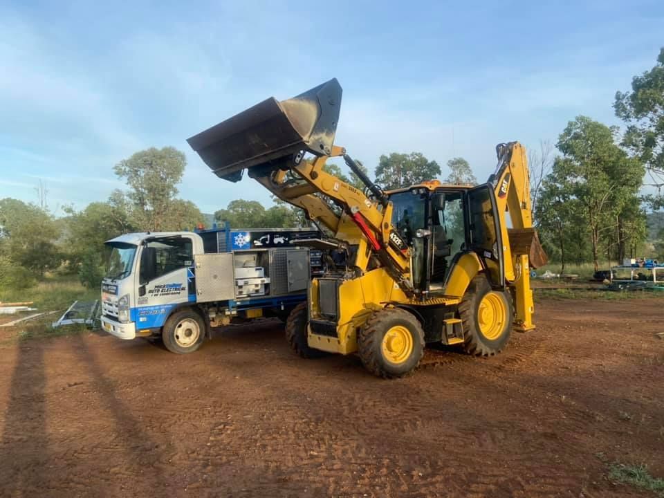A Bulldozer is Parked Next to a Truck in a Dirt Field — Auto Electrician Gunnedah