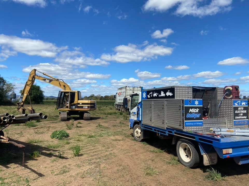 A Truck is Parked in a Field next to an Excavator — Auto Electrician New England & the Northwest