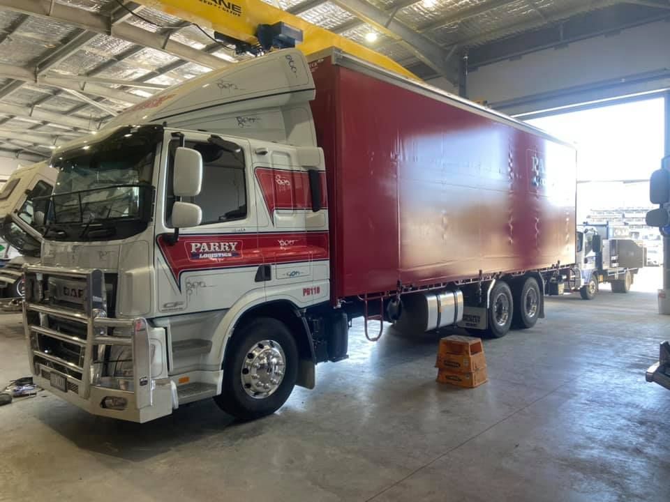 A Red and White Semi Truck is Parked in a Garage — Auto Electrical Service Tamworth