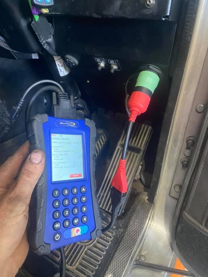 A Person is Holding a Diagnostic Tool in his Hand in a Car — Auto Electrical Service Tamworth