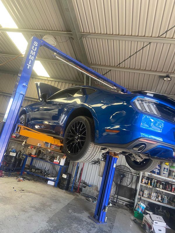 A Blue Mustang is on a Lift in a Garage — Auto Electrical Service Tamworth