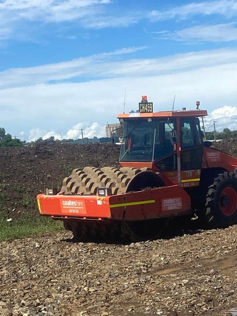 A Red Tractor is Driving Through a Dirt Field — Auto Electrical Repairs Tamworth