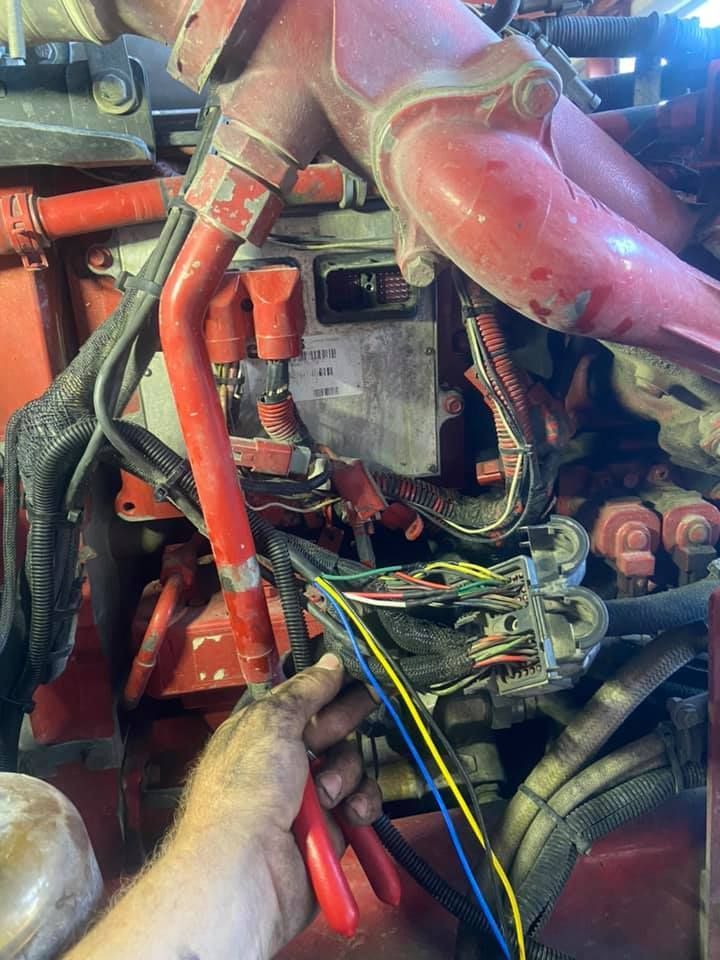 A Person is Working on a Red Engine with a Pair of Pliers — Auto Electrician Armidale