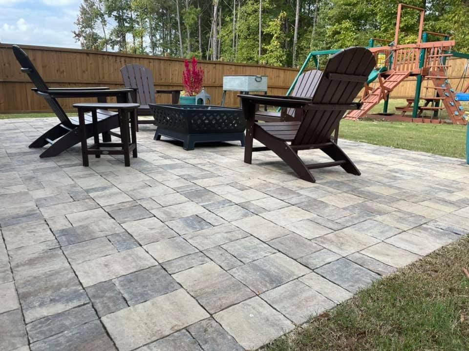 Patio with pavers, Adirondack chairs, fire pit, small table, and a playground.