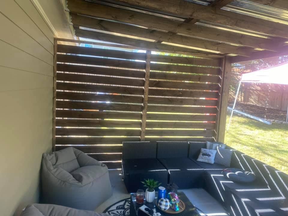 Outdoor patio with sectional sofa, beanbag chair, and slatted privacy screen.