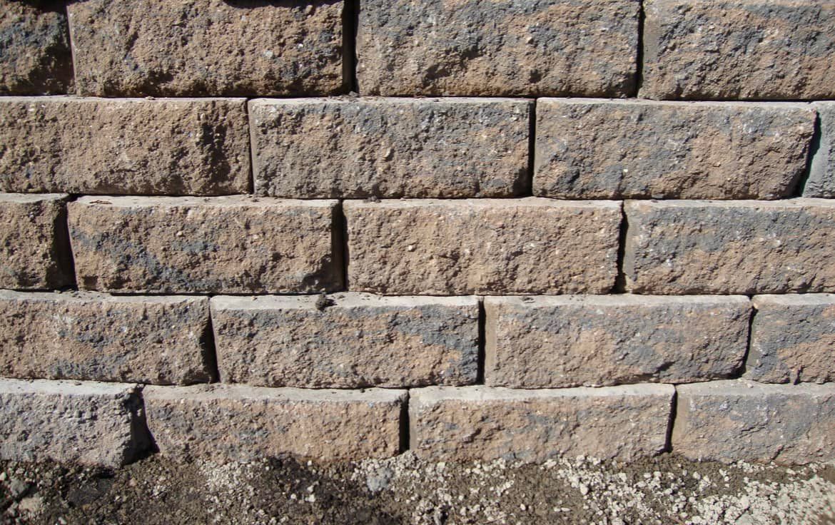 Close-up of a wall constructed with rectangular, multi-colored concrete blocks.