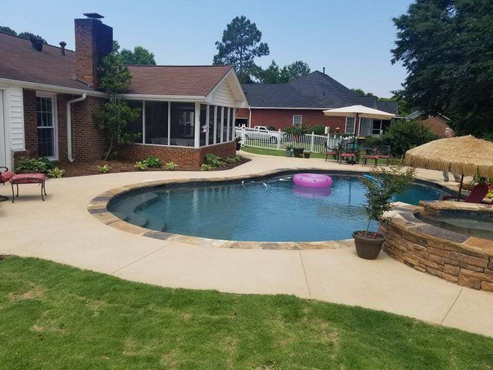 Backyard with pool, patio, and screened porch. Pink inflatable in pool.
