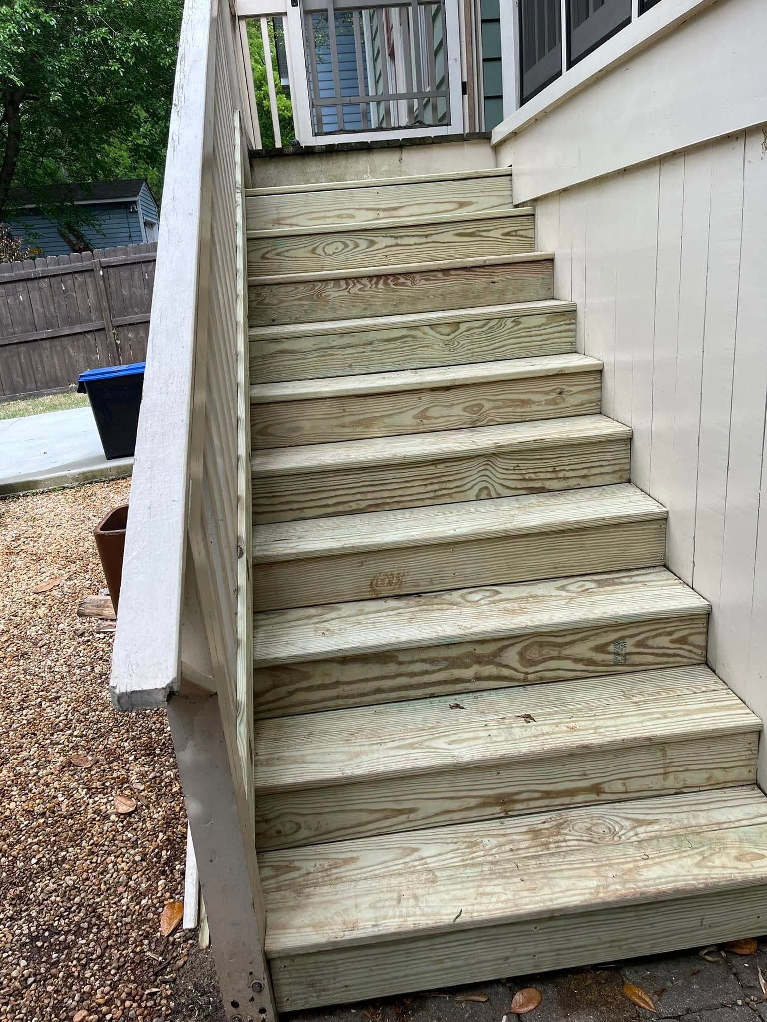 Wooden outdoor staircase leading up, with railing on one side.