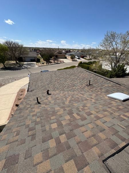 A roof with a lot of shingles on it in a residential area.