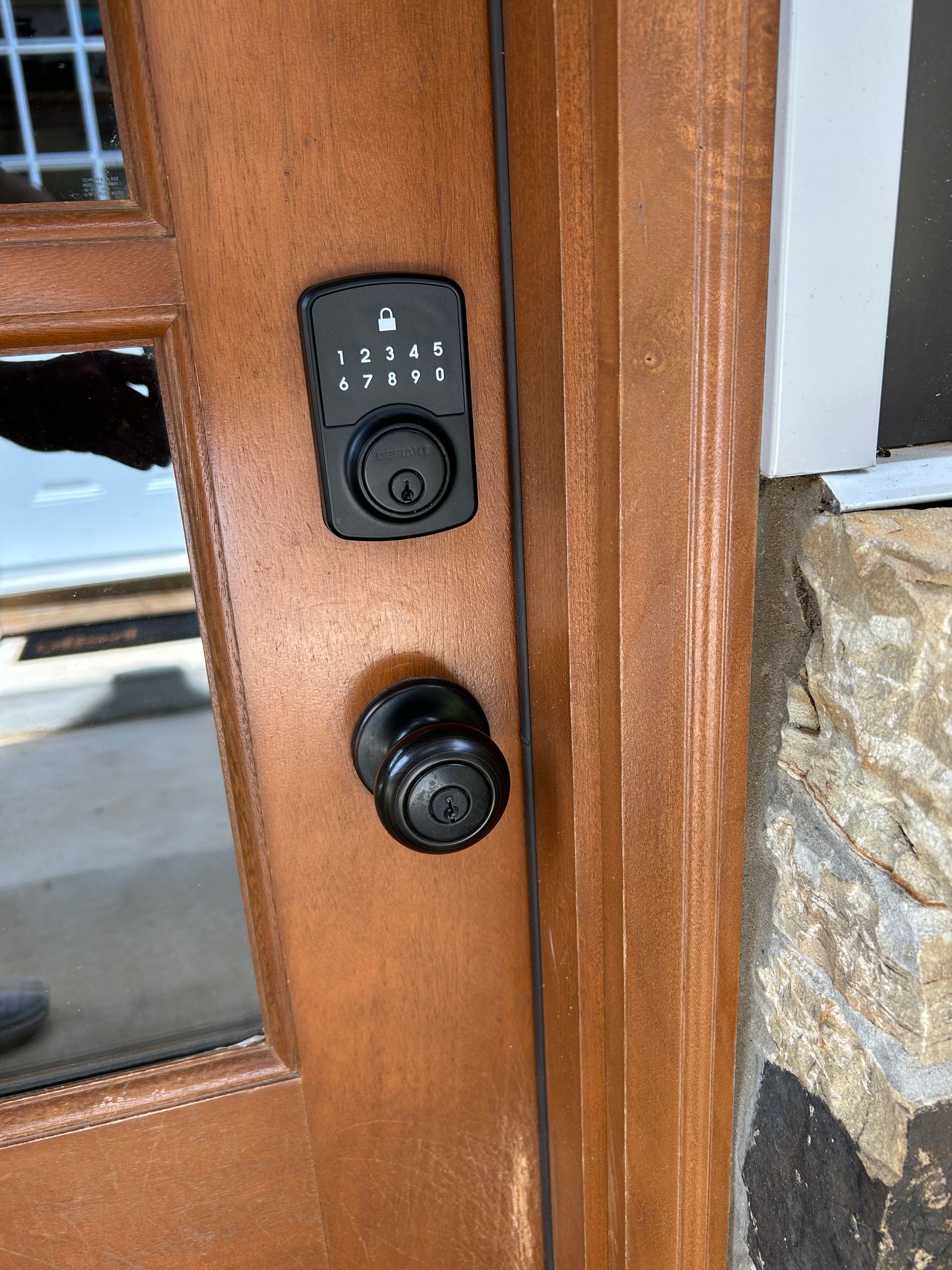 Wooden door with a black digital keypad lock and a black doorknob.