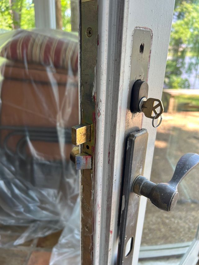 Close-up of a door lock with a key inserted. The door is slightly ajar.