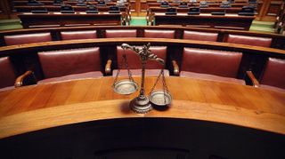 court room interior with scales of justice on the bench
