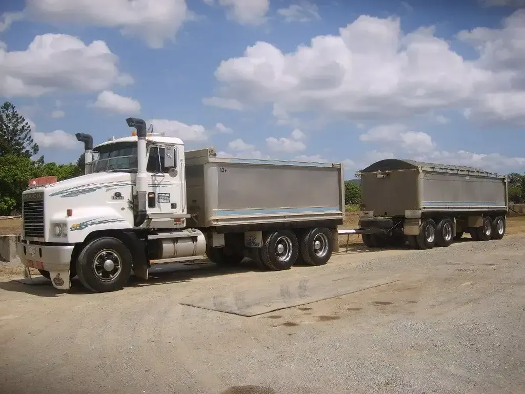 A white dump truck is parked in a gravel lot — Geisler Truck & Trailer Wheel Alignments In Pleystowe, QLD