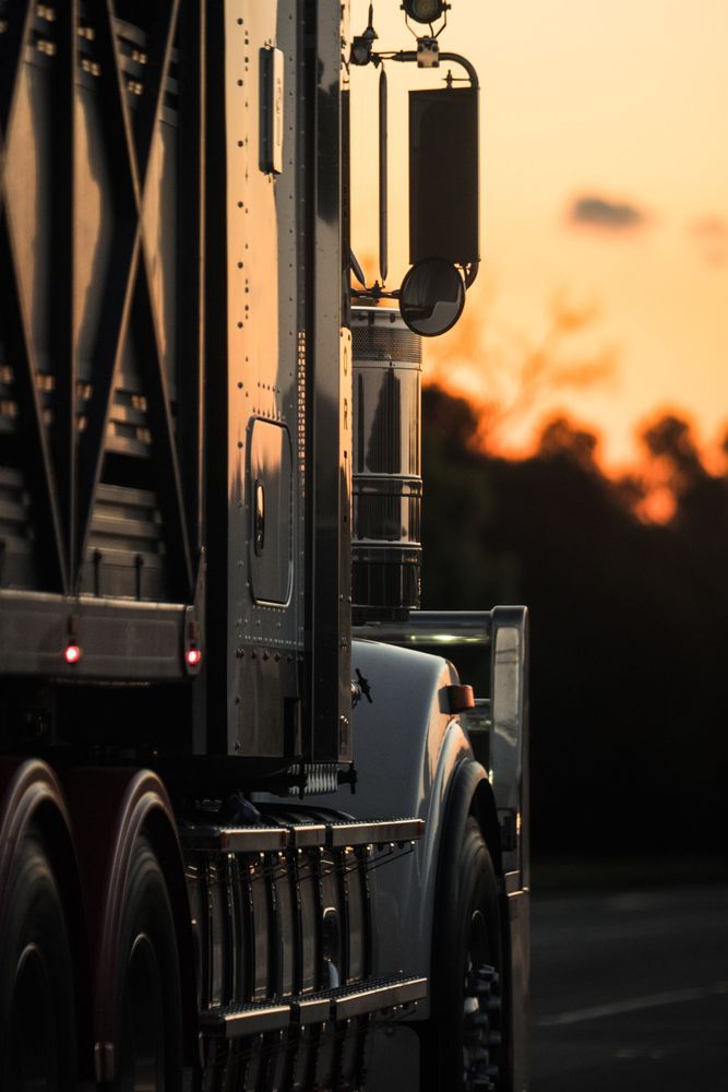 A Semi Truck Is Driving Down A Road At Sunset — Geisler Truck & Trailer Wheel Alignments In Pleystowe, QLD