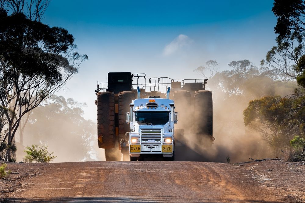 A Large Truck Is Driving Down A Dirt Road — Geisler Truck & Trailer Wheel Alignments In Mackay, QLD