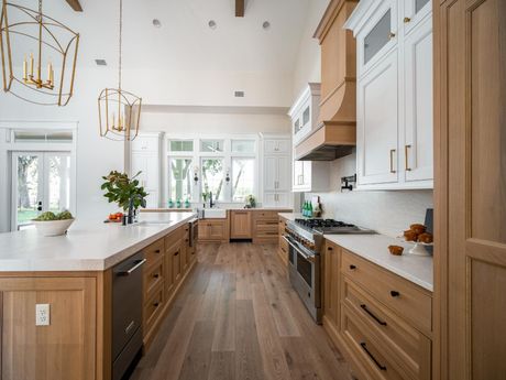 Spacious kitchen with light wood cabinets, white countertops, and stainless steel appliances.
