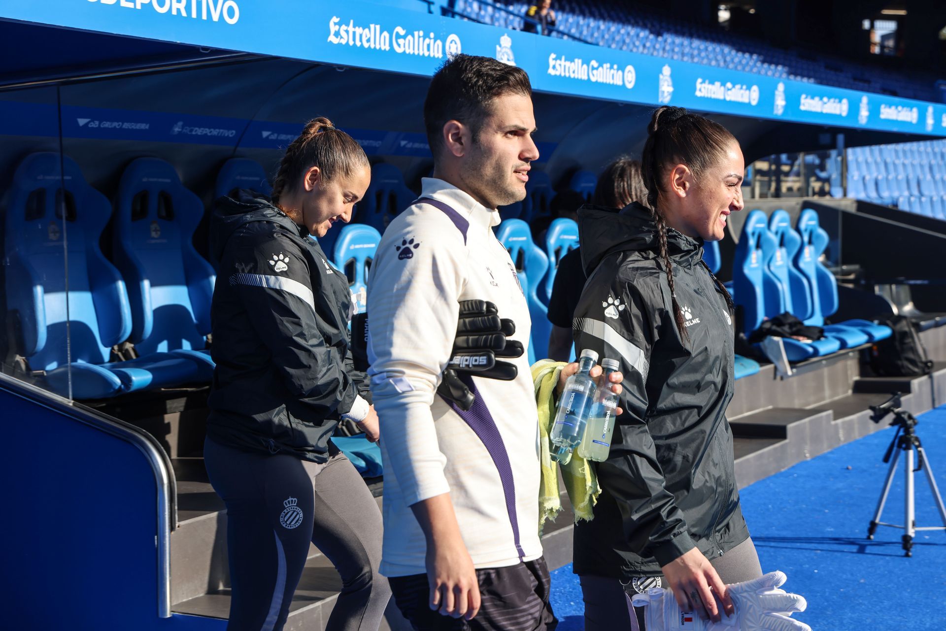 A group of people are standing in front of a soccer stadium.