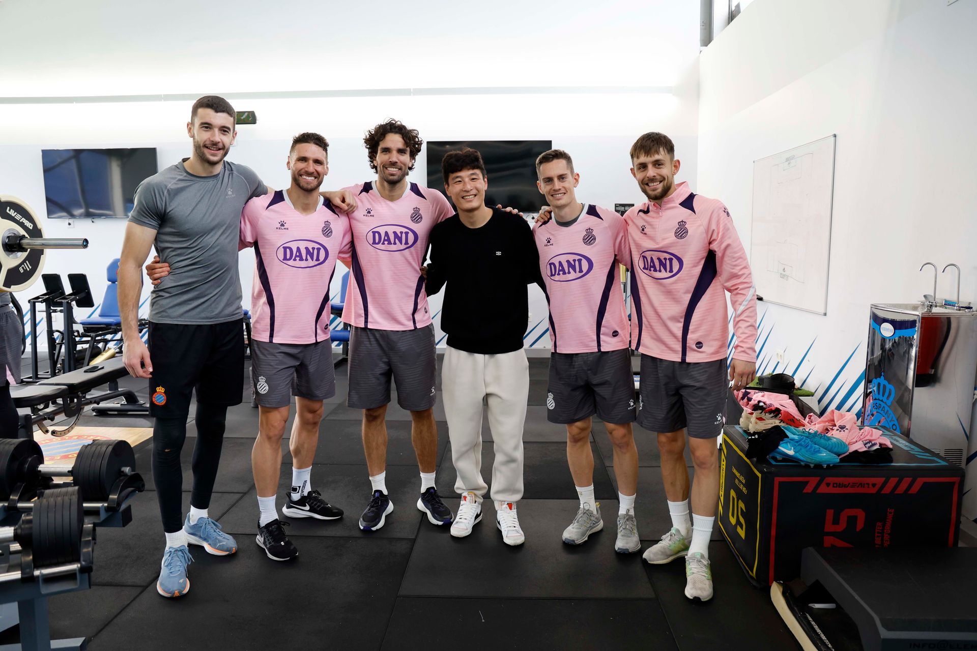 A group of men are posing for a picture in a gym.