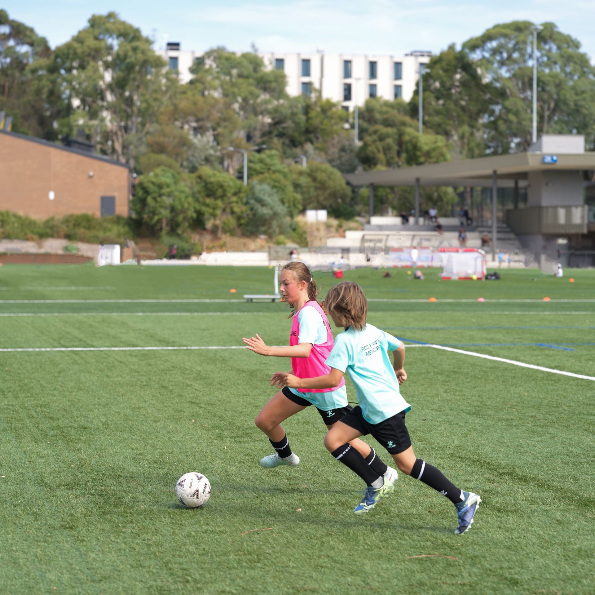 A boy and a girl are playing soccer during RCDE Melbourne training session.