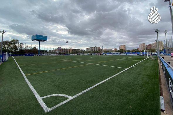 A soccer field with a cloudy sky in the background