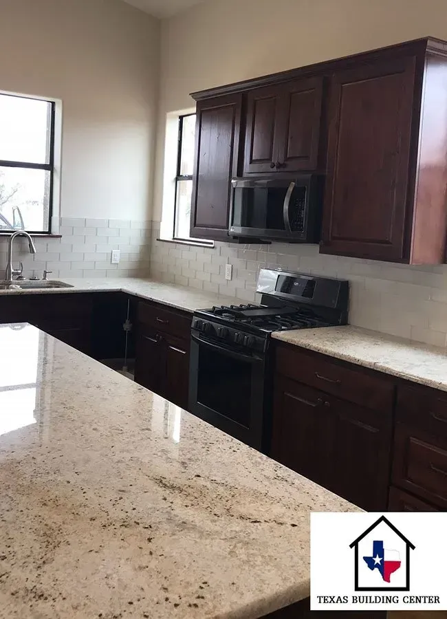 Kitchen with dark wood cabinets, granite countertops, and a gas range.
