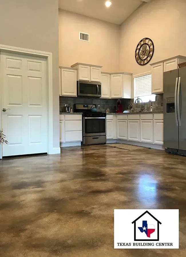 Kitchen with white cabinets, stainless steel appliances, and stained concrete floor.